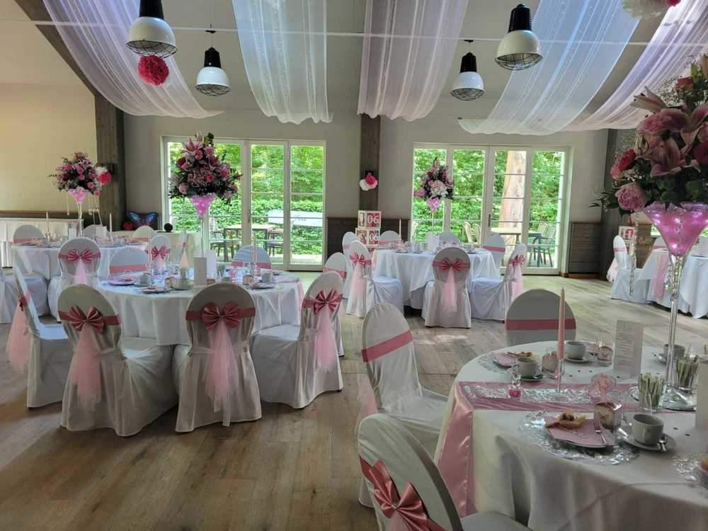 Hochzeitstische im Saal mit rosa Dekoration